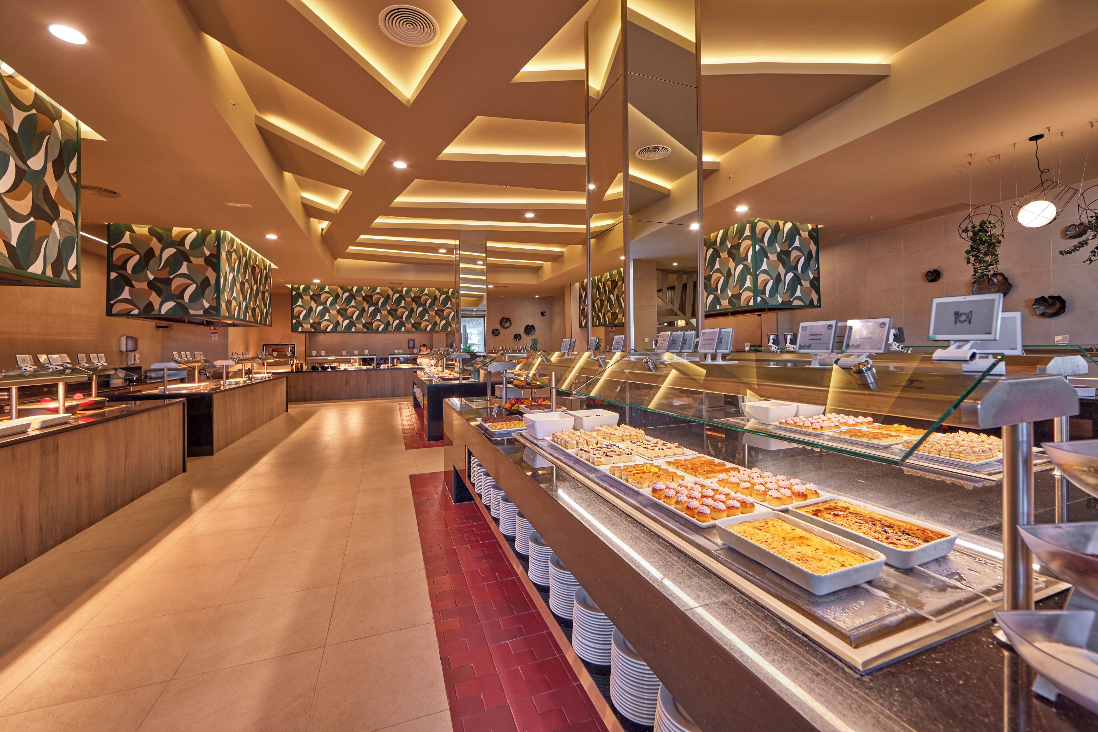A buffet area with multiple food stations, a long counter, and a seating area with tables.