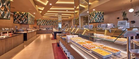 A buffet area with multiple food stations, a long counter, and a seating area with tables.