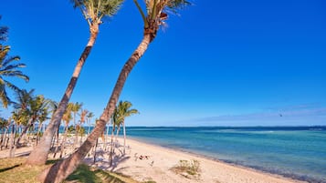 Plage, sable blanc, chaises longues, parasols