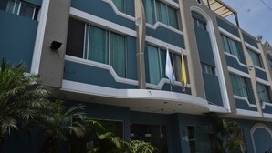 Un hotel de varios pisos con un diseño arquitectónico moderno, con amplias ventanas y techo plano.