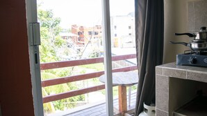 Una cocina con estufa a gas y vistas a un balcón con barandilla.