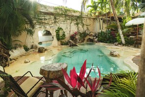 Una piscina al aire libre, sombrillas, sillones reclinables de piscina
