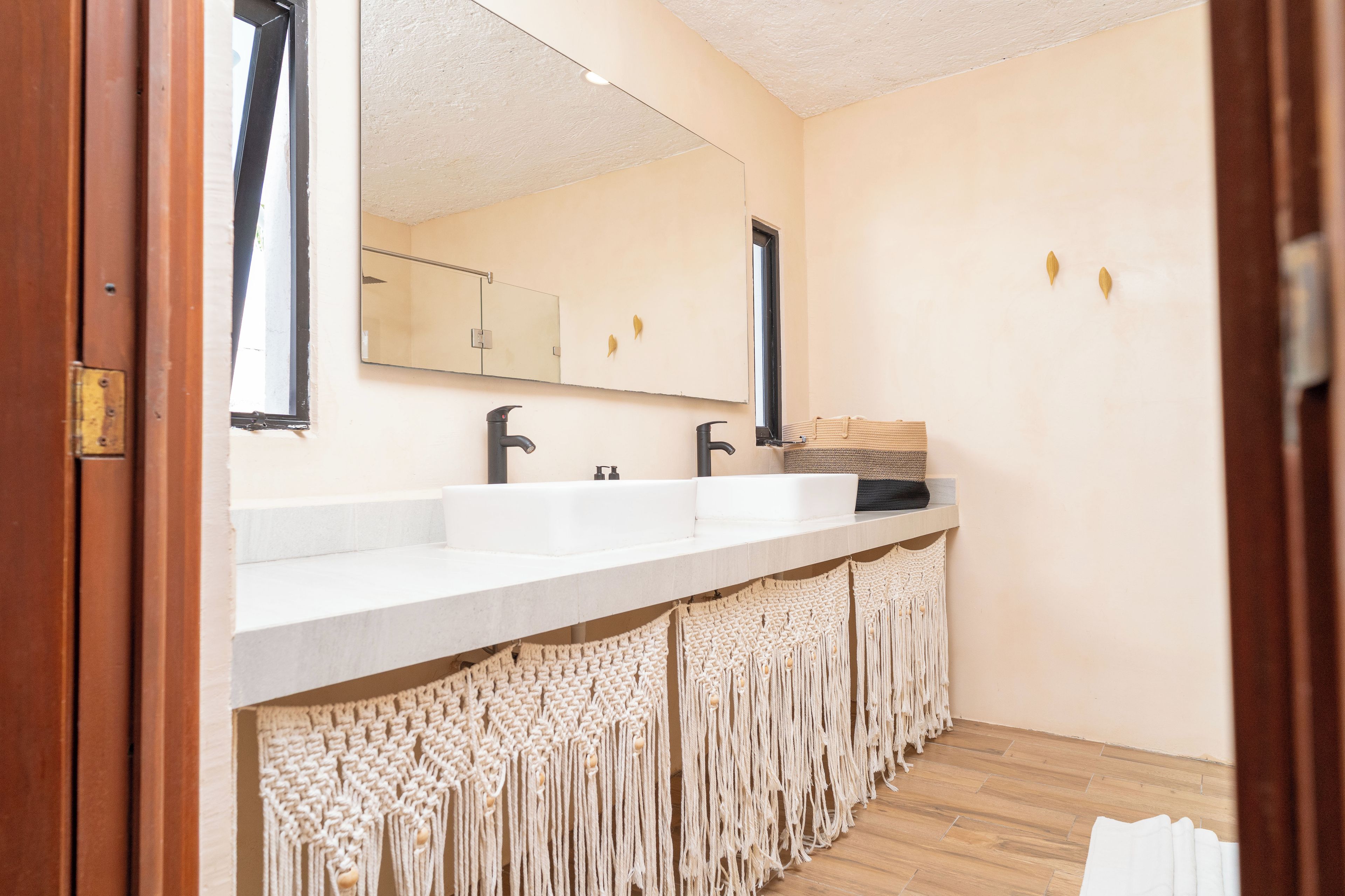 Une salle de bain avec un lavabo blanc, un miroir et un porte-serviettes.