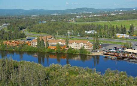 A lakeside hotel with multiple buildings, a dock, and a road leading to a highway.
