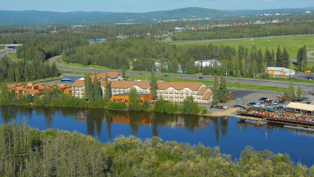 A lakeside hotel with multiple buildings, a dock, and a road leading to a highway. - Pike's Waterfront Lodge (Fairbanks)