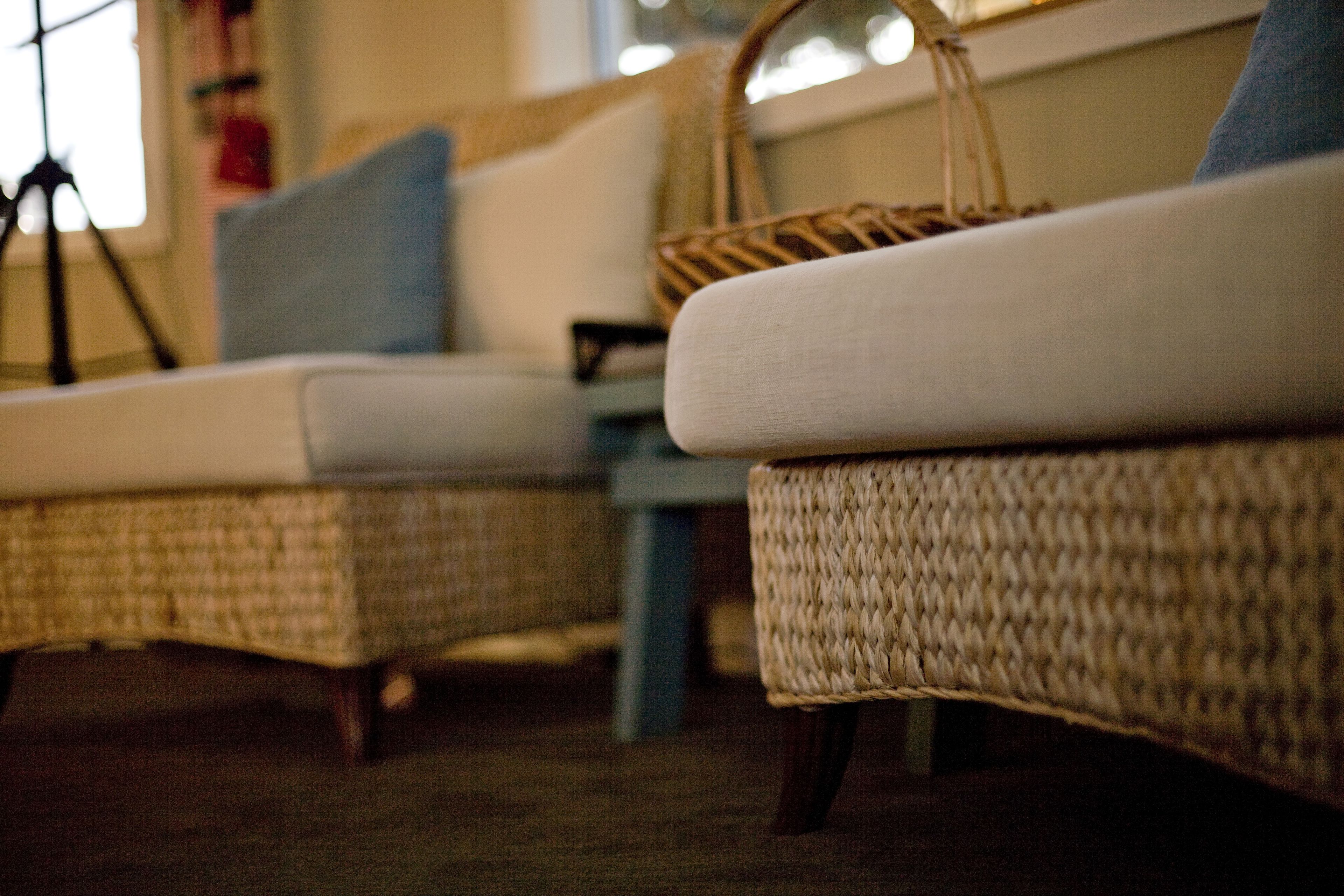 Wicker furniture with a cushion and a woven basket.