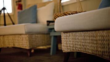 Muebles de mimbre con un cojín y una cesta tejida.