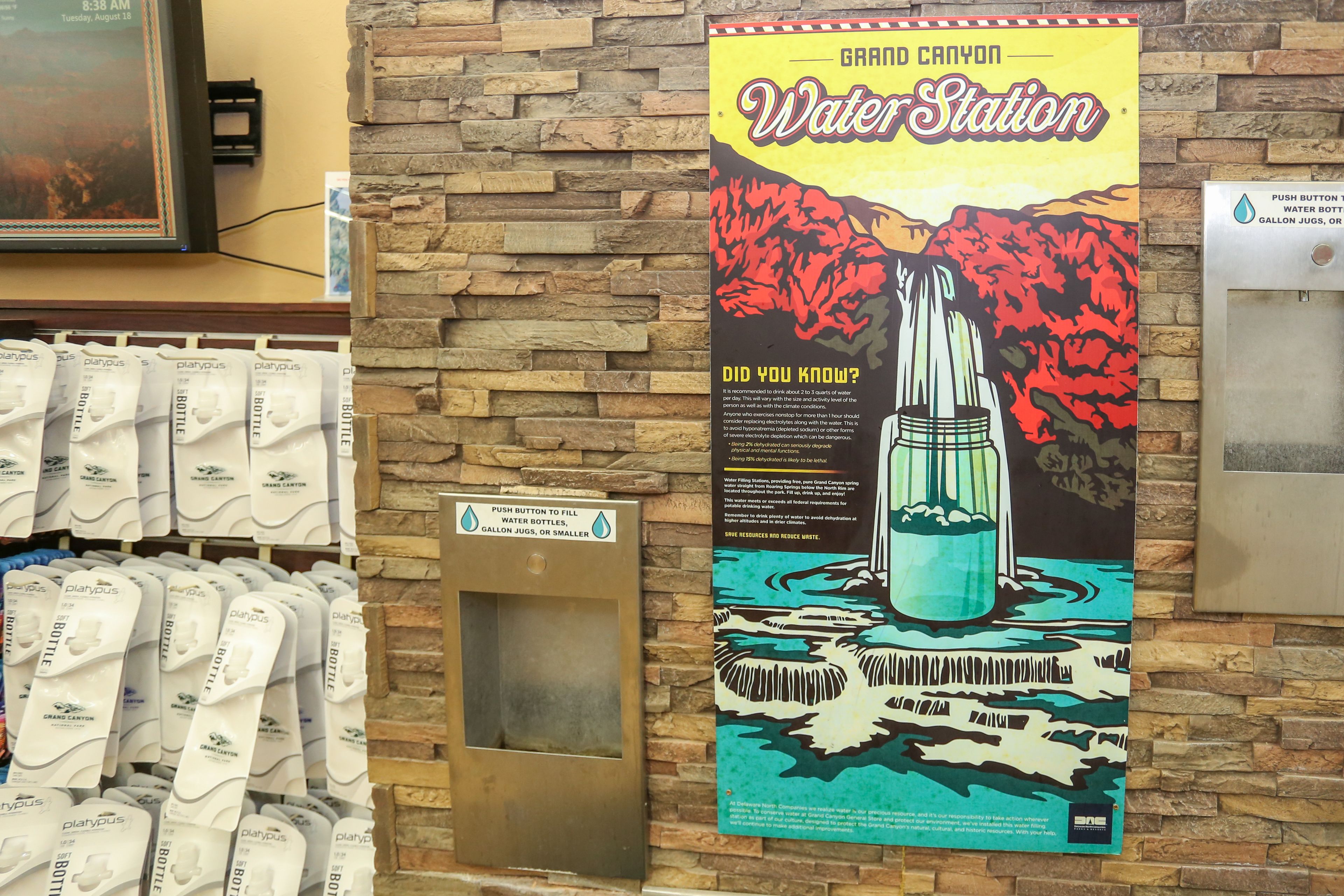 Un point d’eau agrémenté d’une affiche représentant le point d’eau du Grand Canyon, d’un bouton-poussoir pour remplir les bouteilles d’eau et d’un panneau indiquant la zone de remplissage des bouteilles d’eau.