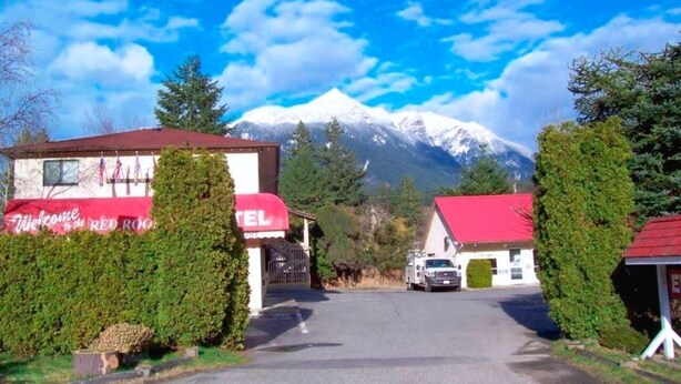 A hotel with a red roof and a sign welcoming guests to the Red Rock.