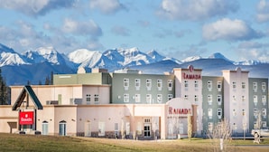 Un hotel Ramada con un diseño moderno, que presenta un techo plano y un letrero llamativo.