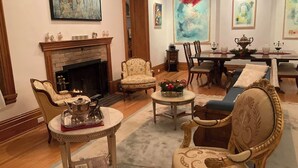 Un salón tradicional con chimenea, muebles ornamentados y obras de arte en las paredes.