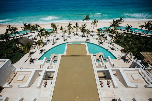 A resort pool with a view of the beach and ocean.