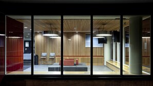A modern interior with a wooden ceiling, large windows, and seating areas. - University of Calgary - Seasonal Residence (Calgary)