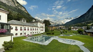 Un patio con piscina, rodeado de edificios y montañas.