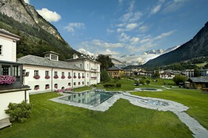 Un patio con piscina, rodeado de edificios y montañas.