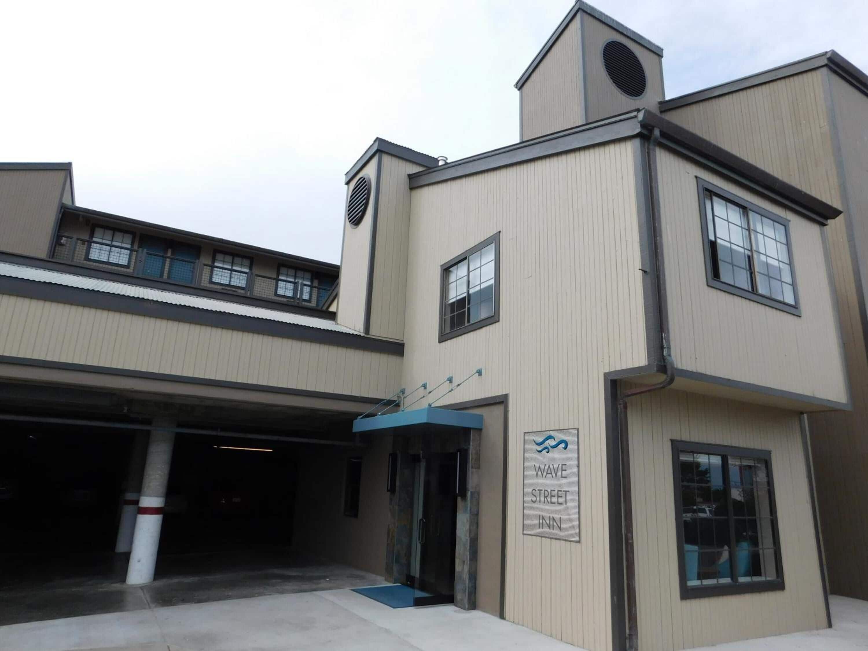 A building with a sign for the Wave Street Inn.