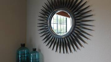 Decoración de pared redonda con un diseño de rayos solares y una ventana en el centro.