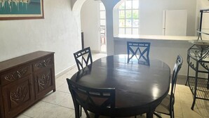 A dining area with a round table and chairs, a wooden cabinet, and a painting on the wall. - Hotel Handall Cancun (Cancun)