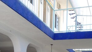 A multi-level atrium with blue railings, white columns, and potted plants. - Hotel Sarabi Barra de Navidad (Barra de Navidad)