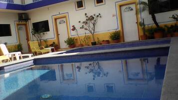 Alberca al aire libre, sombrillas en la alberca y camastros