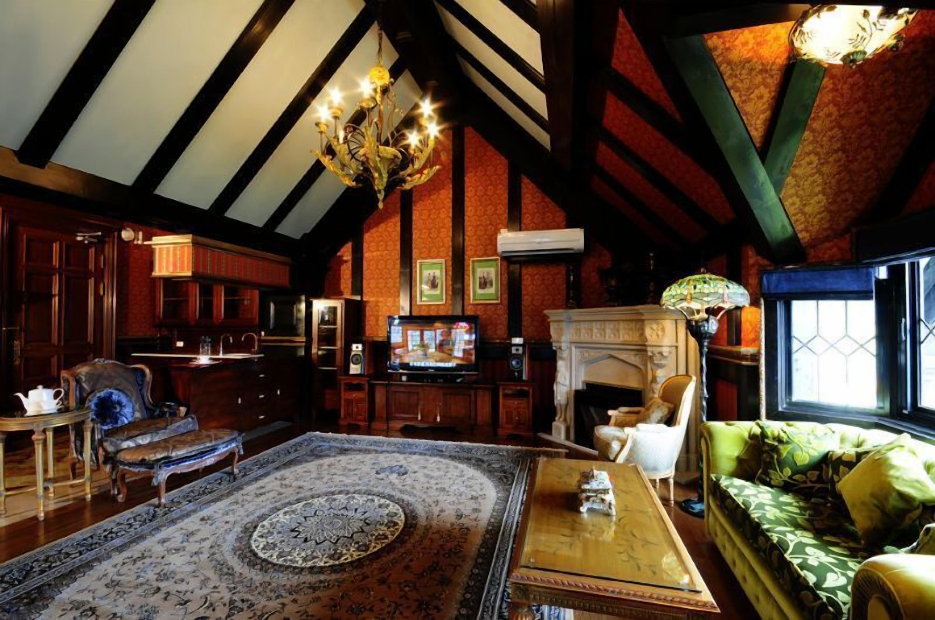 A traditional room with a fireplace, wooden furniture, and a chandelier.