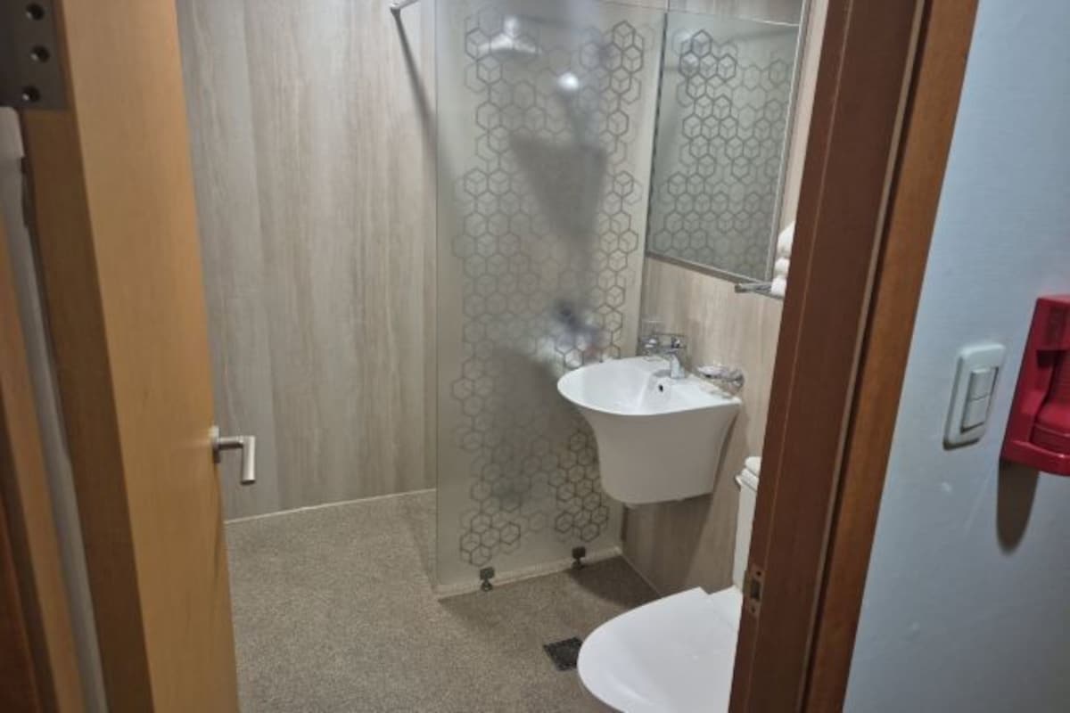 A bathroom with a shower, sink, and toilet.
