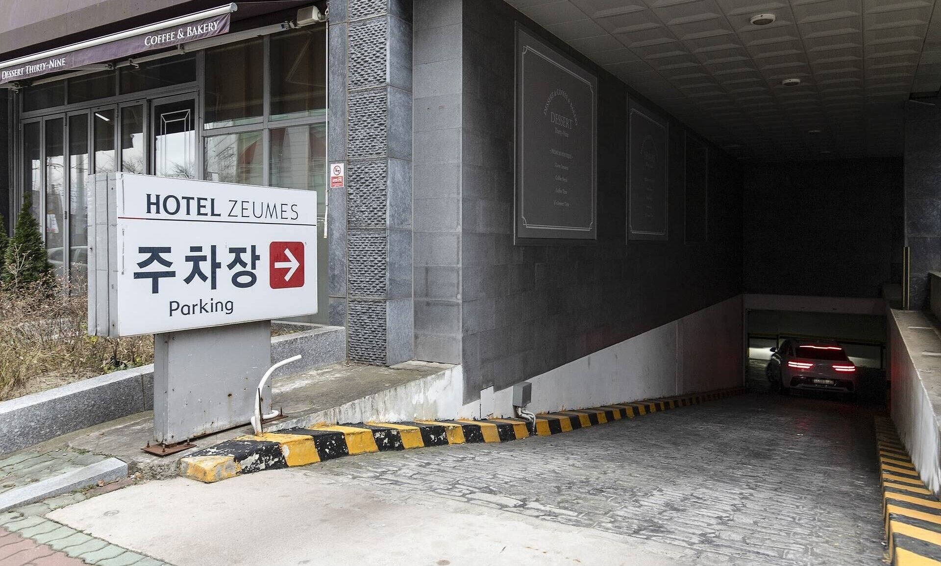 A hotel entrance with a sign indicating a parking area.