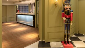 A hotel lobby with a checkered floor, a reception desk, and a nutcracker statue. - Urtrip Hotel (Taipei)