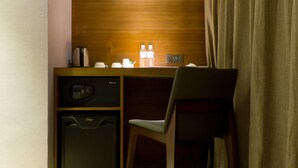 A compact workspace with a desk, a chair, a microwave, and a mini fridge. - Urtrip Hotel (Taipei)