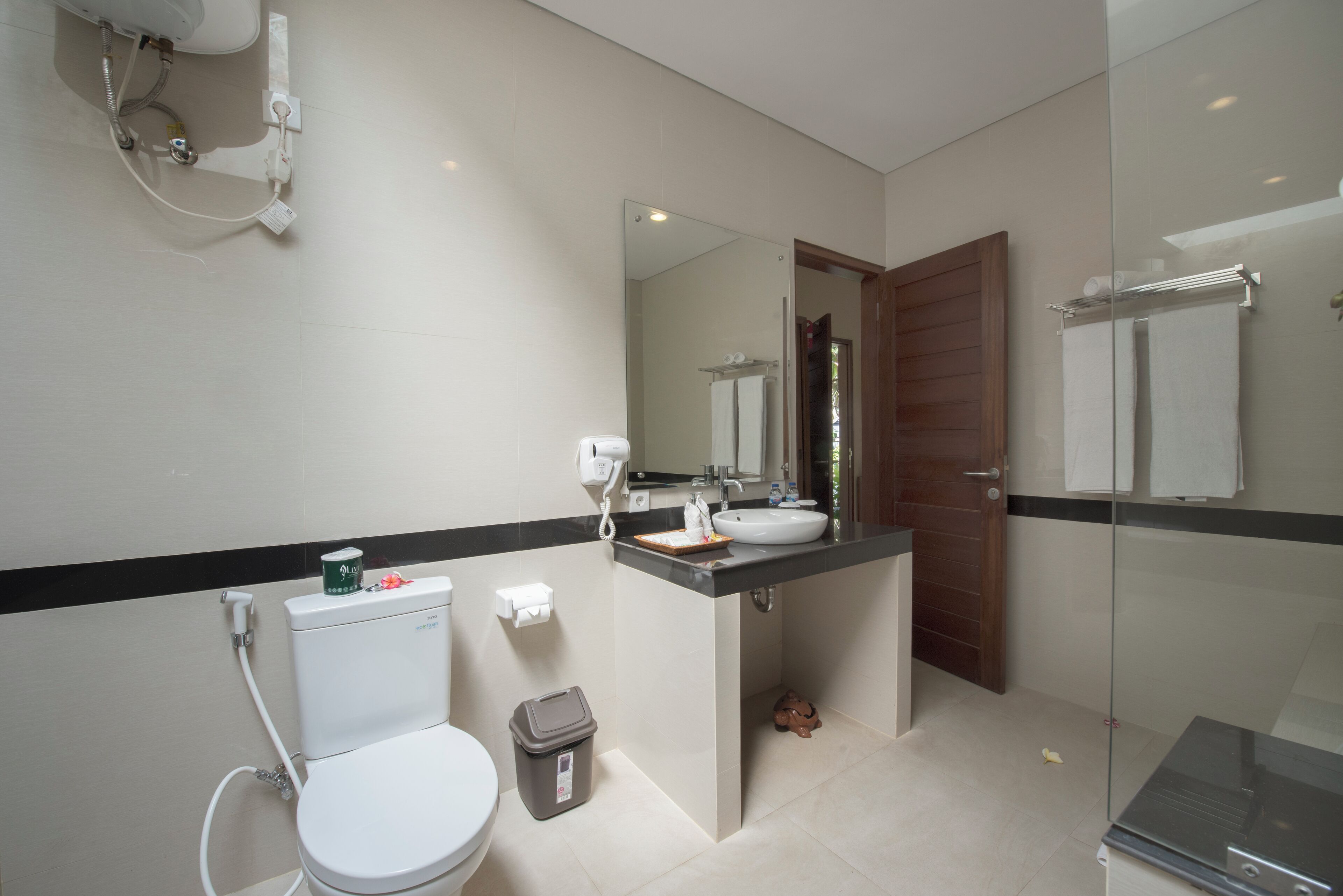 Un baño moderno con inodoro, lavamanos y zona de ducha.