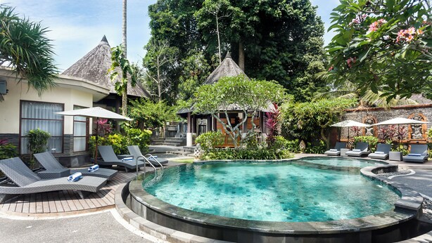 A circular hot tub surrounded by lounge chairs and umbrellas, with a tropical garden and a gazebo in the background. - Kadiga Villas Ubud by GenuineHost (Ubud)