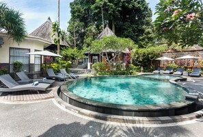 A circular hot tub surrounded by lounge chairs and umbrellas, with a tropical garden and a gazebo in the background. - Kadiga Villas Ubud by GenuineHost (Ubud)