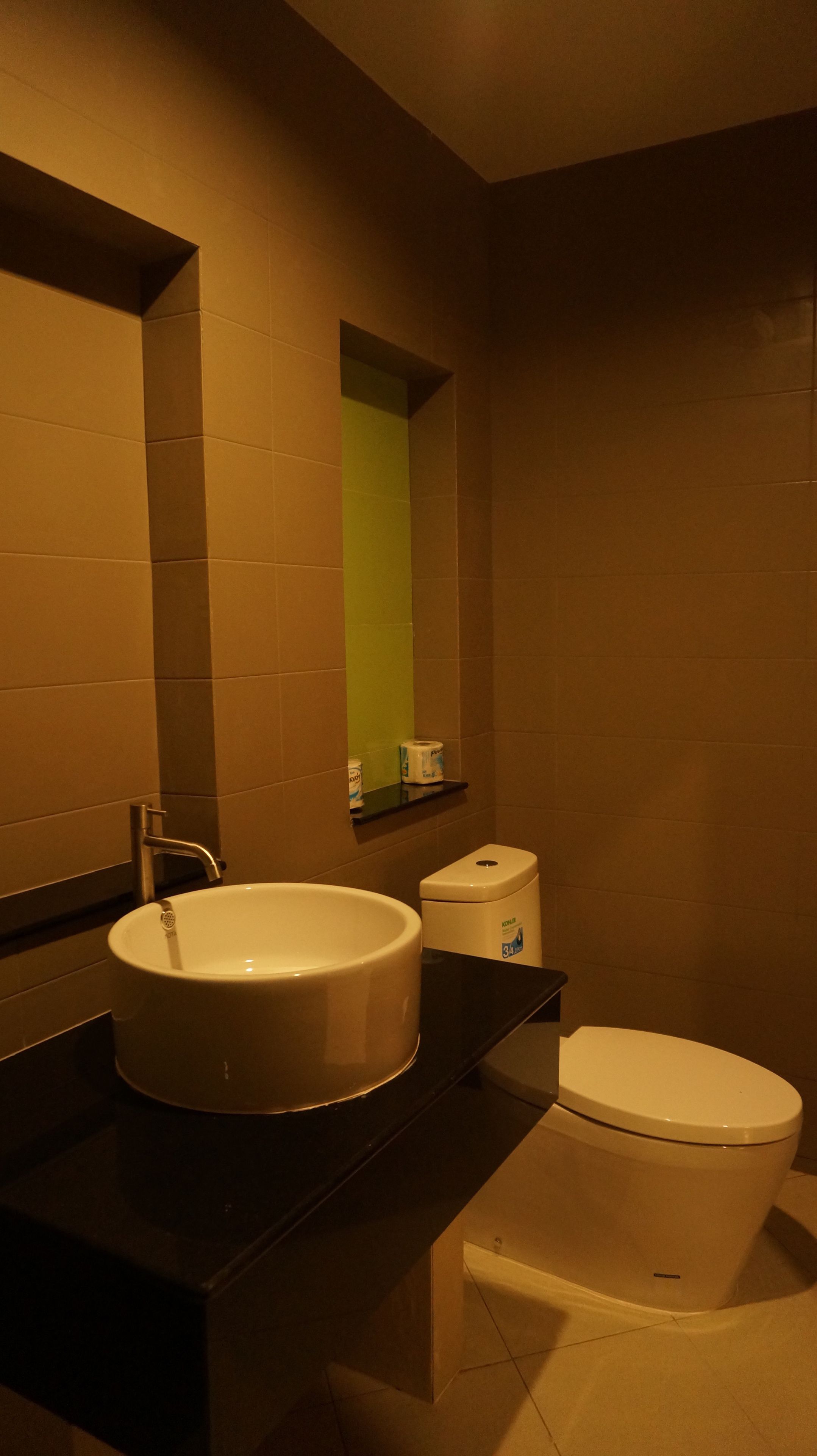 A bathroom with a sink, toilet, and a mirror.