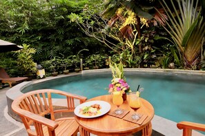 Una piscina al aire libre, sillones reclinables de piscina