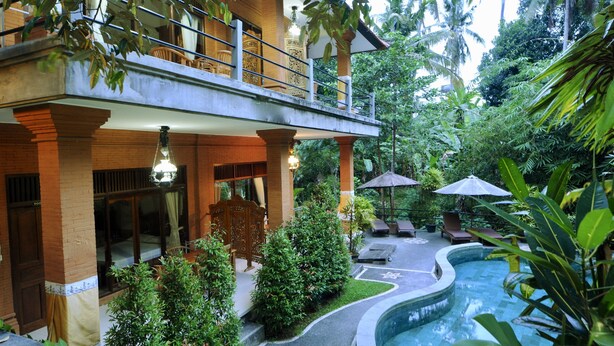 A hotel with a pool, outdoor seating, and lush greenery. - Rahayu 2 Bungalows (Ubud)