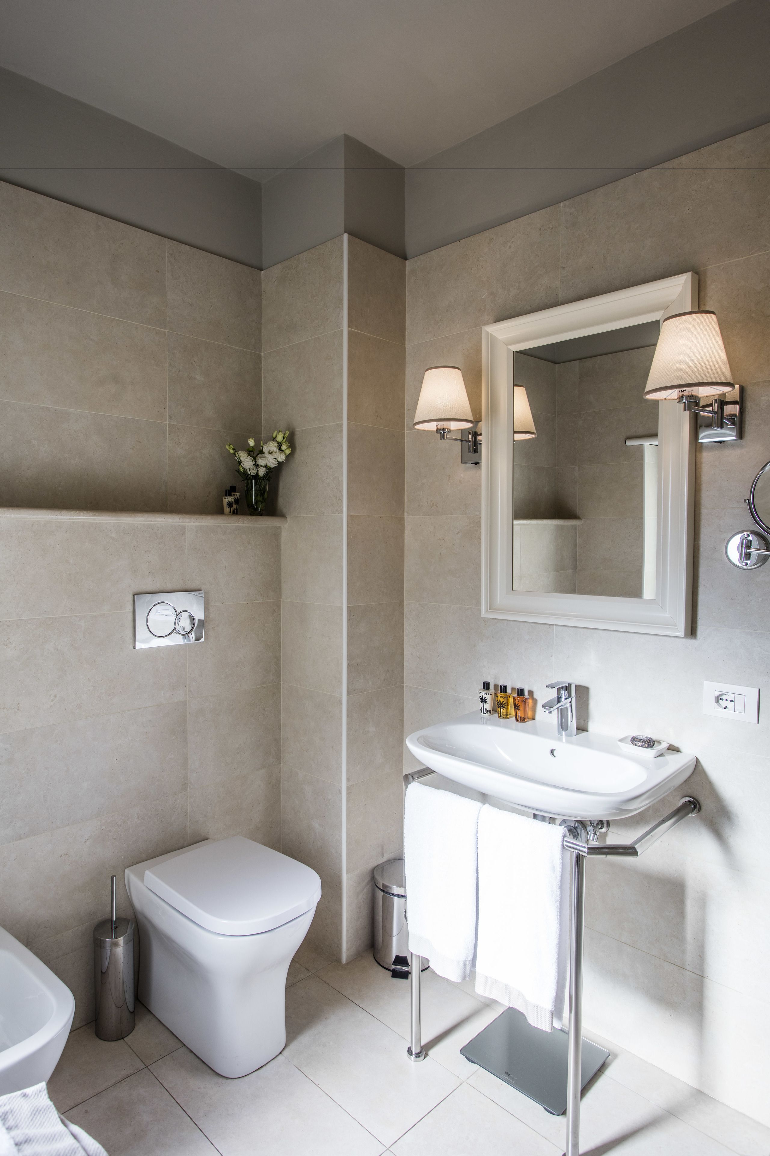 Un baño moderno con inodoro, lavamanos y espejo.