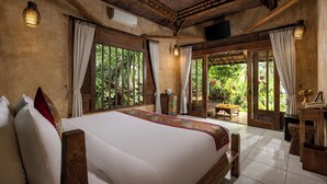 A spacious bedroom with a large bed, wooden ceiling, and a view of lush greenery outside. - Senetan Villas and Spa Resort (Payangan)