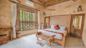 A bedroom with a wooden bed, a bench, a desk, and a window with curtains. - Senetan Villas and Spa Resort (Payangan)