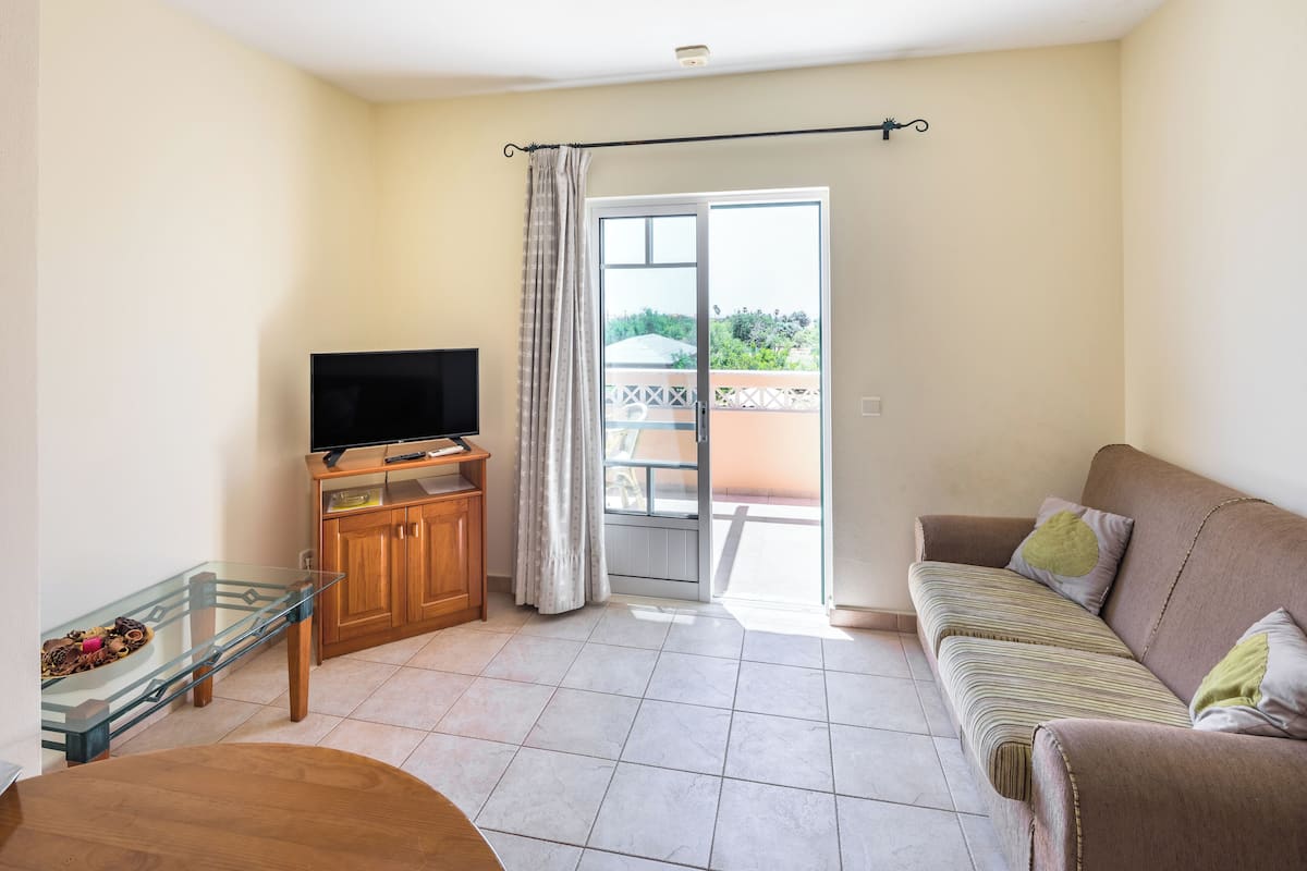 Departamento Confort, 2 habitaciones | Área de sala de estar | Televisión de pantalla plana de 32 pulgadas con canales por cable