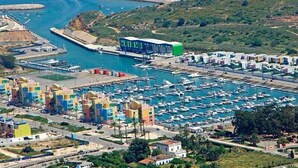 A marina with numerous boats docked, a green bus, and colorful buildings. - Monte dos Avós Apartamentos, Albufeira (Albufeira)