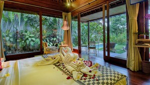 A room with a bed, large windows, and a view of greenery. - Samkhya Villas (Ubud)