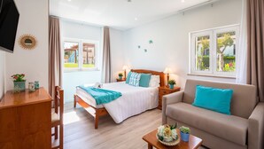 A well-lit room with a bed, a sofa, a desk, and a window with curtains. - Flôr da Laranja, Albufeira (Albufeira)