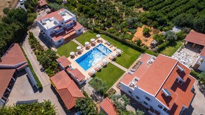 An aerial view of a residential area with a swimming pool surrounded by lounge chairs and umbrellas, adjacent to a vineyard. - Flôr da Laranja, Albufeira (Albufeira)