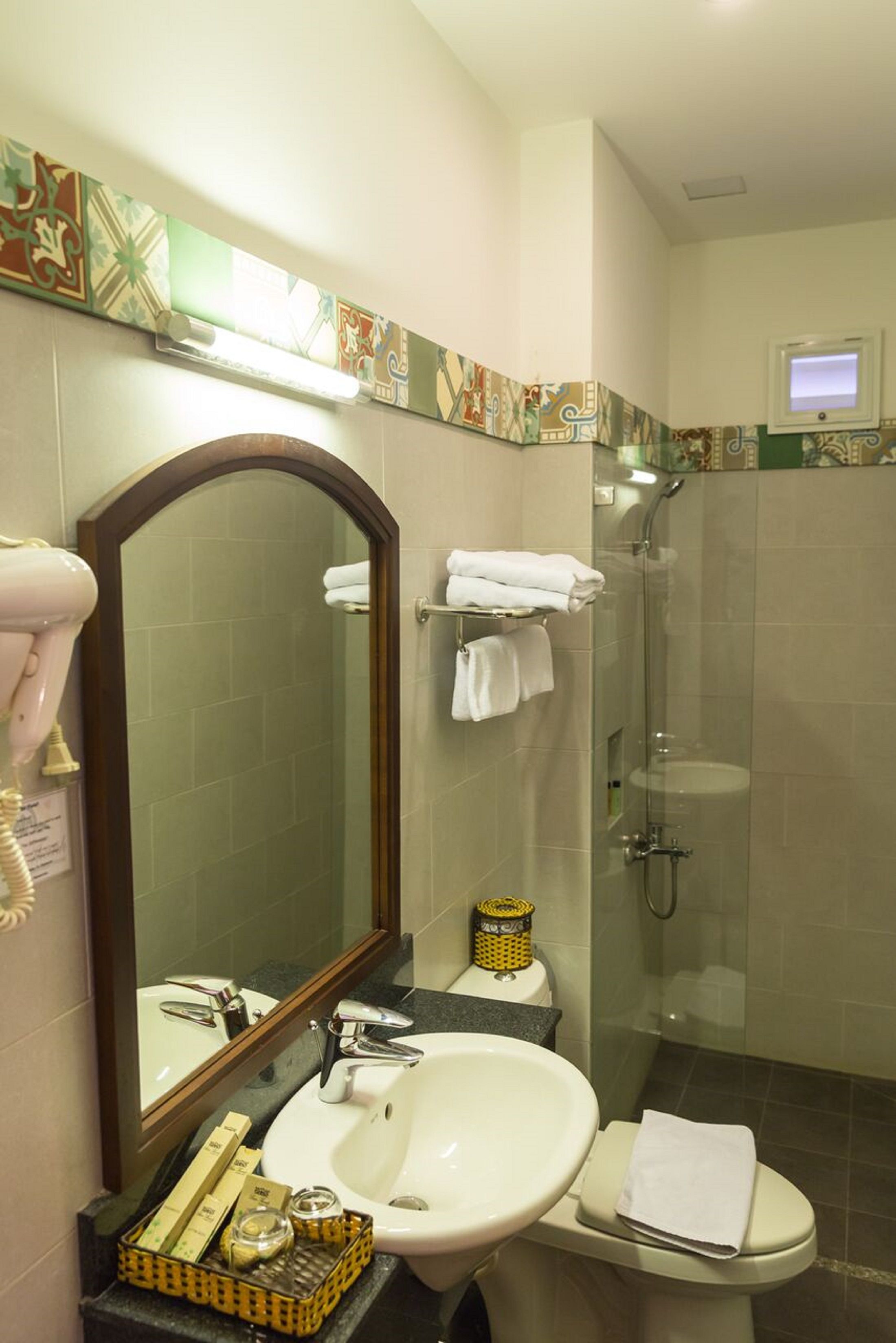 A bathroom with a sink, mirror, and a glass-enclosed shower.