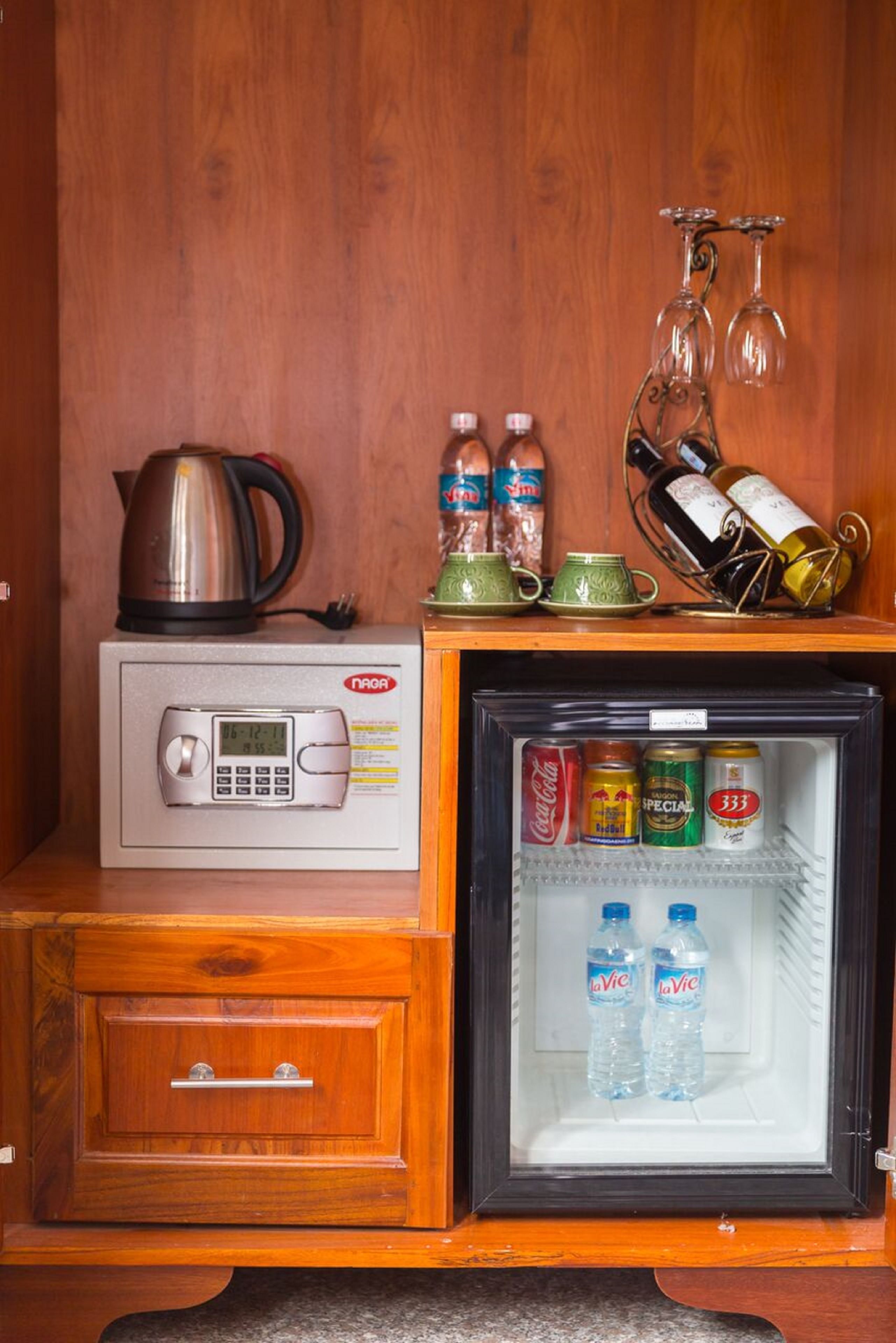 A compact kitchenette with a microwave, a small refrigerator, and a wooden cabinet.