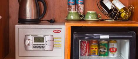 A compact kitchenette with a microwave, a small refrigerator, and a wooden cabinet.