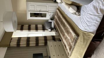 Une chambre à coucher avec un lit, une commode, un bureau et une lampe.