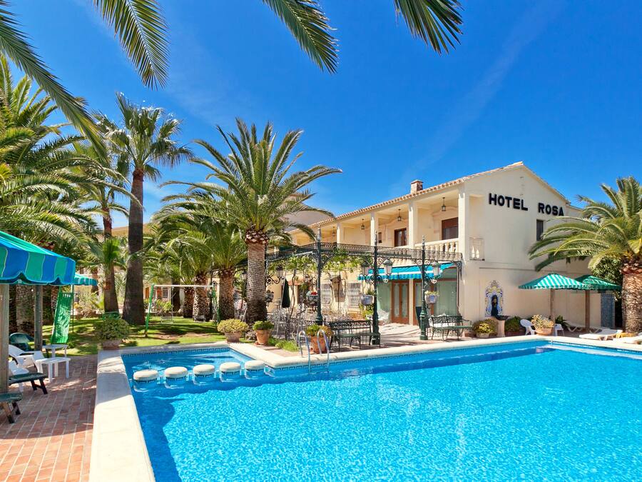 Una piscina al aire libre, sombrillas, tumbonas