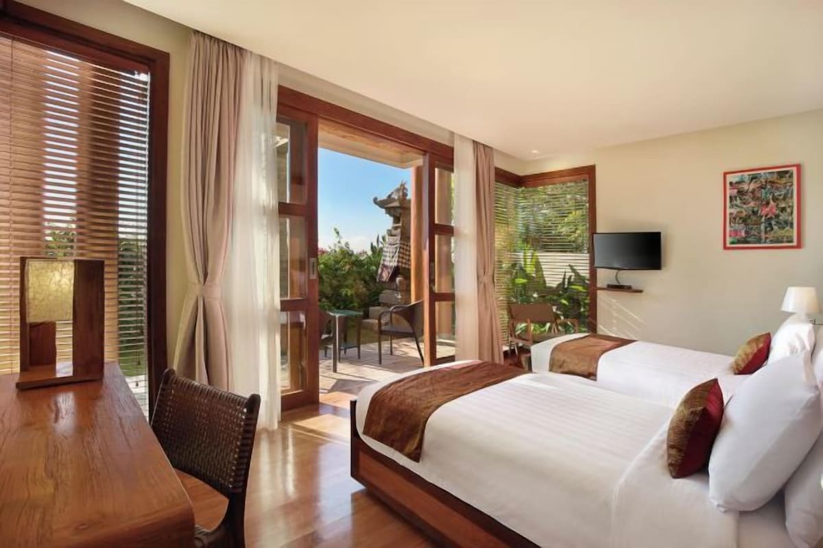 Una habitación de hotel con una cama grande, una mesa de comedor y un televisor.