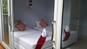 Habitación de hotel con dos camas, cada una con un corredor rojo y almohadas blancas.